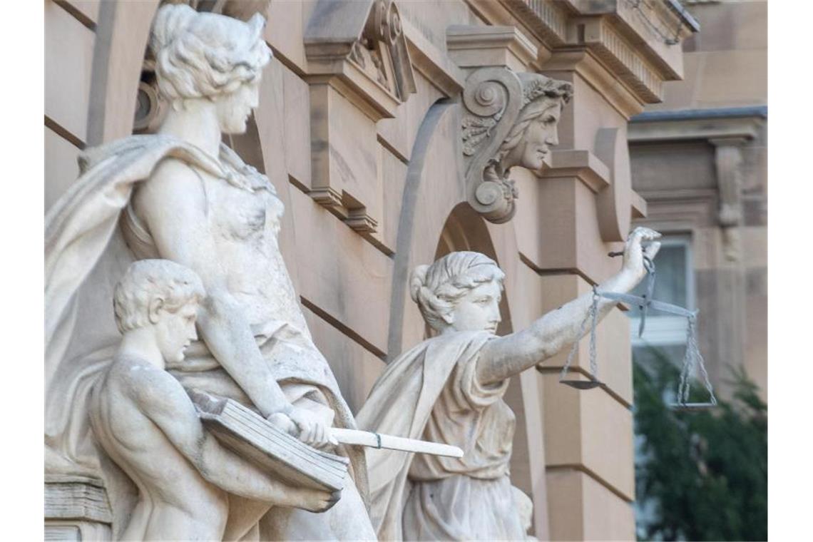 Vor einem Gerichtsgebäude steht u.a. eine Statue der Justitia. Foto: Stefan Puchner/dpa/Symbolbild