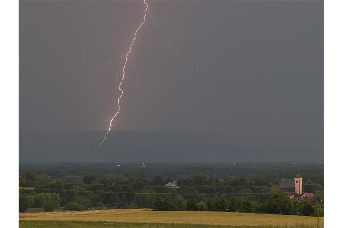 Vor einigen Tagen: Ein Blitz leuchtet hinter einem Stadtteil von Hanau. Foto: Sebastian Gollnow/dpa