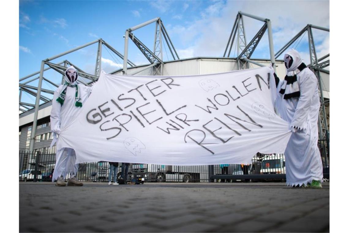 Vor verschlossenen Toren: Zwei als Geist verkleidete Gladbach-Fans vor dem Stadion. Foto: Jonas Güttler/dpa