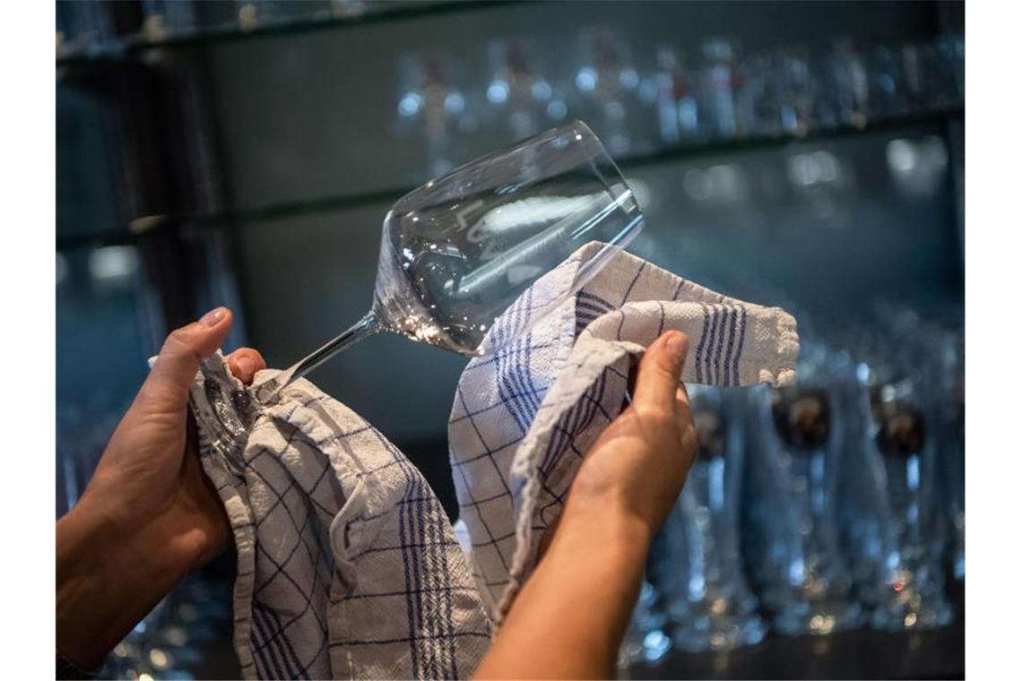 Hotels, Cafes und Restaurants öffnen wieder - unter Auflagen Vorbereitung auf die Gäste: In einem Restaurant werden die Gläser poliert. Foto: Sina Schuldt/dpa