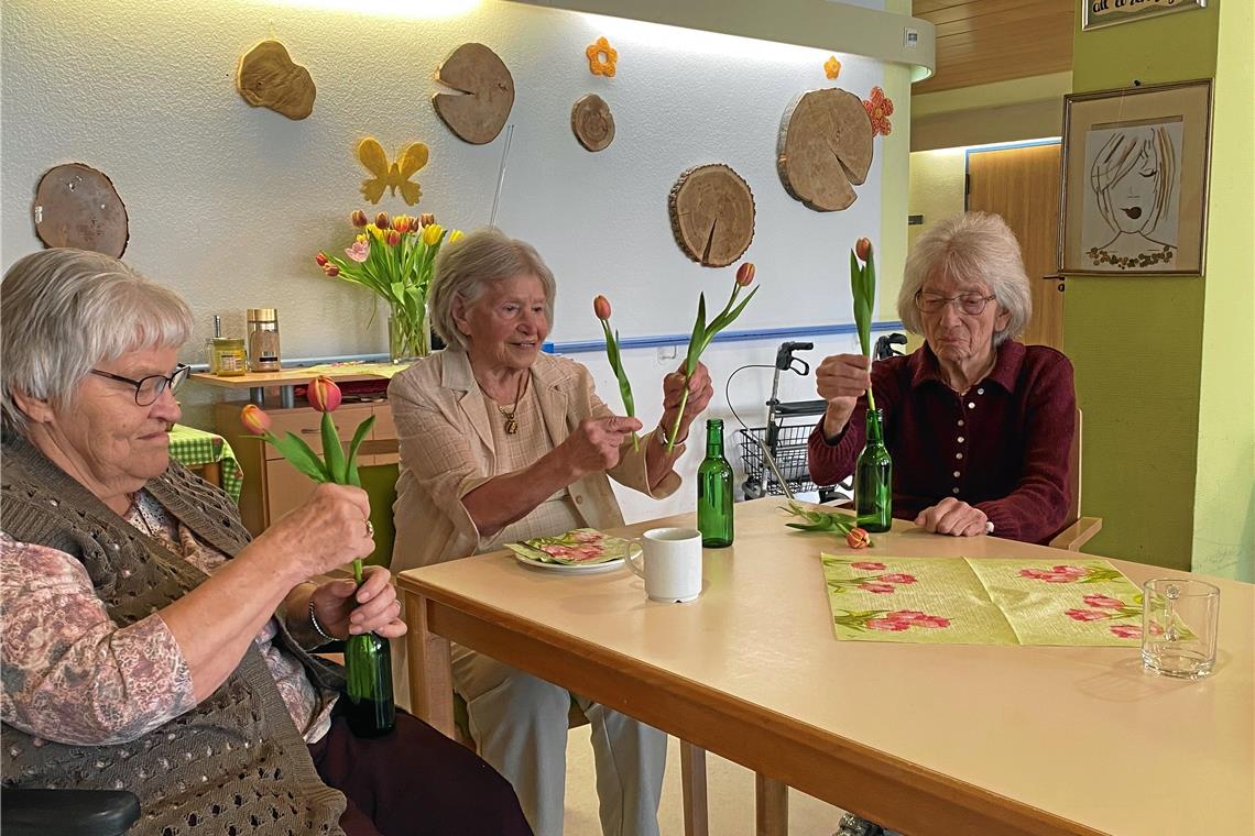 Vorbereitungen für das Frühlingsfest, das ein Wohnbereich im Staigacker gestern gefeiert hat: Die geimpften Bewohnerinnen richten die Blumendeko her. Aktivitäten wie diese sind im Staigacker derzeit nur im festen Gruppenverband möglich. Wenn 90 Prozent der Bewohner geimpft sind, soll es wieder Angebote in großer Runde geben können. Foto: Stiftung Altenheime Backnang