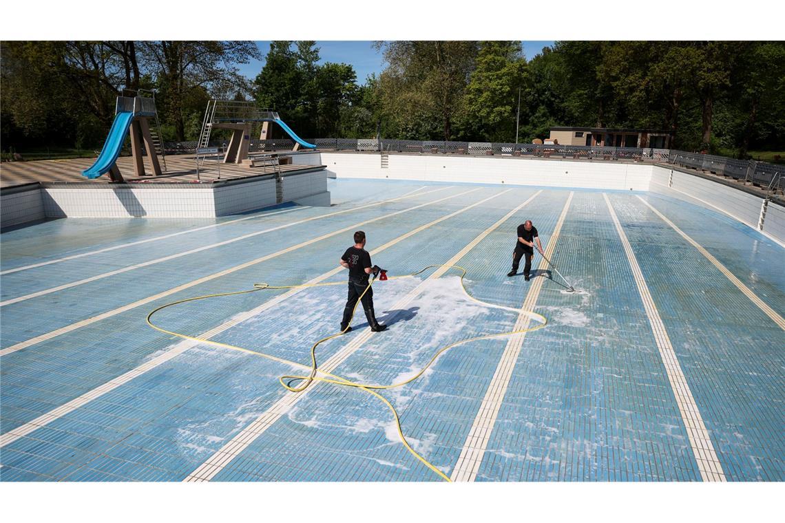 Bilder des Tages Vorbereitungen für die Freibadsaison in Hamburg: Mitarbeiter eines Reinigungsunternehmens säubern das Sprung- und Schwimmerbecken im Freibad Bondenwald.