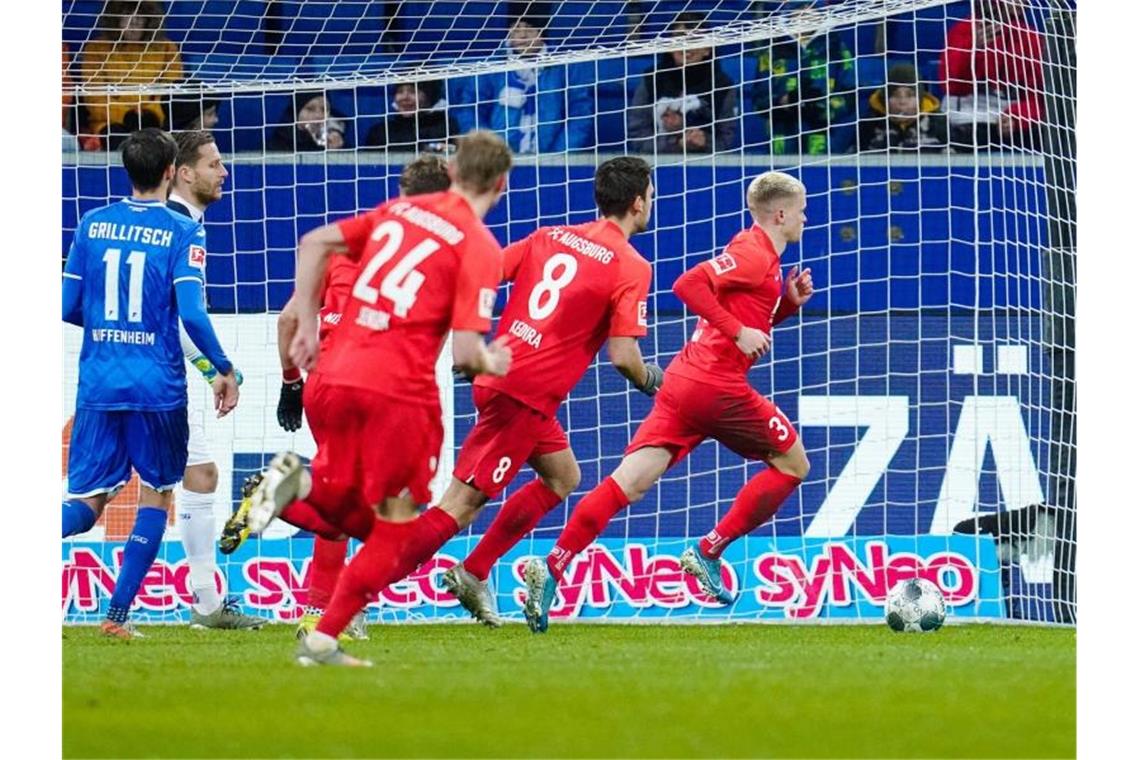 Vorentscheidung: Augsburgs Doppeltorschütze Philipp Max (r) lässt sich nach seinem Elfmetertreffer zum 2:1 feiern. Foto: Uwe Anspach/dpa