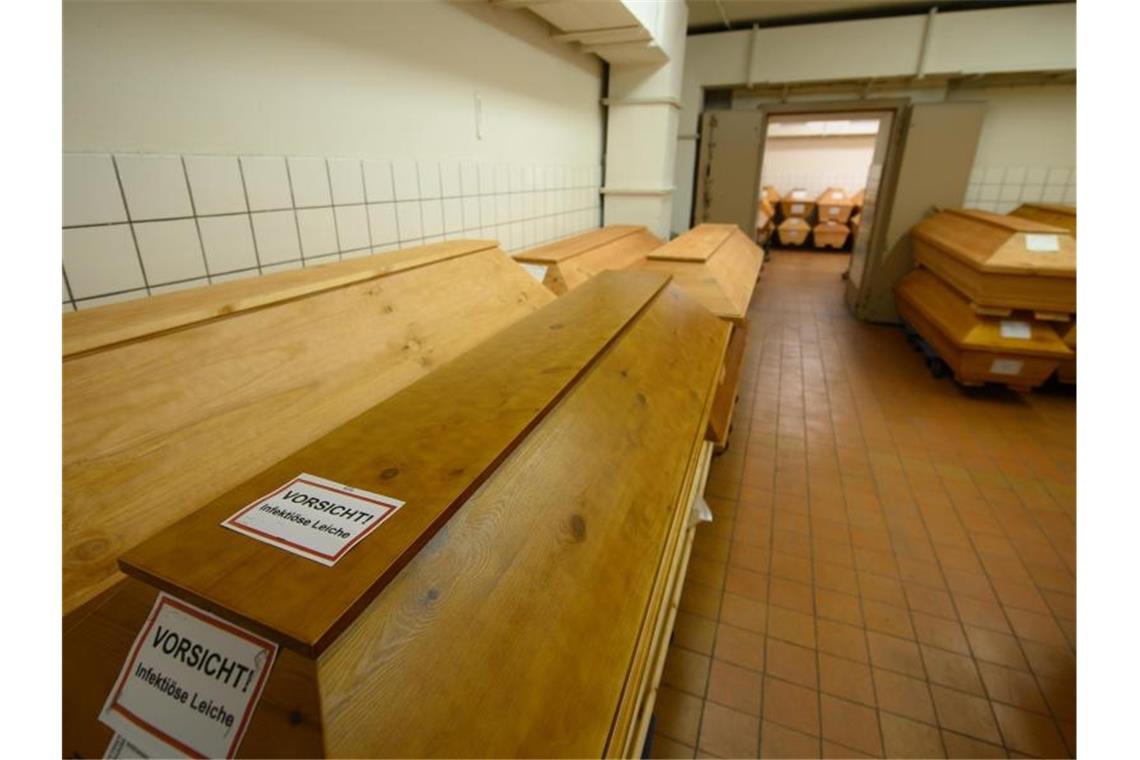 Mehr als 50.000 Corona-Tote in Deutschland „Vorsicht infektiöse Leiche“ steht auf einem Sarg. Mehr als 50.000 Menschen sind an Corona gestorben. Foto: Robert Michael/dpa-Zentralbild/dpa