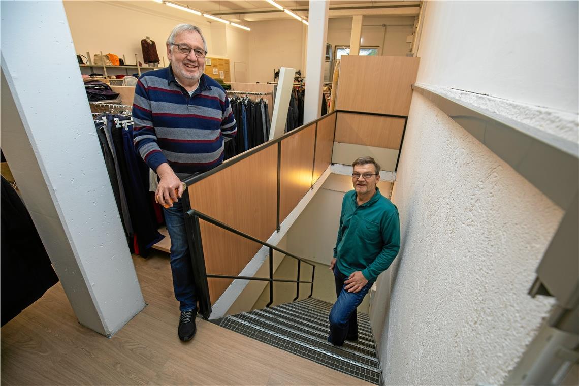 Beim DRK stehen notgedrungen alle Räder still Vorsitzender Klaus-Dieter Fackler (rechts) und stellvertretender Vorsitzender Kurt Zeller vom DRK-Ortsverein zeigen den Weg von der Kleiderhalle hinunter zum Kursraum. An dieser Treppe, die allerdings noch gedreht wird, soll der Treppenlift zum Untergeschoss installiert werden. Foto: A. Becher