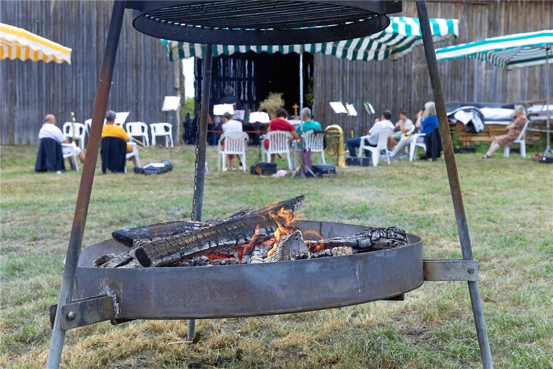 Während des Gottesdienstes brennt im Hintergrund schon der Grill. Wer möchte, der kann Mitgebrachtes auf den Rost legen.