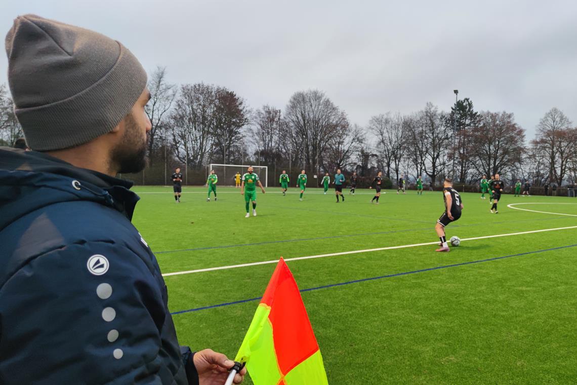 Während des Spiels schwenkt er die Fahne und ersetzt damit den Linienrichter.