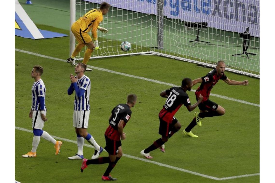 Während die Berliner enttäuscht sind, jubeln die Frankfurter nach dem Treffer von Bas Dost (r). Foto: Michael Sohn/POOL AP/dpa