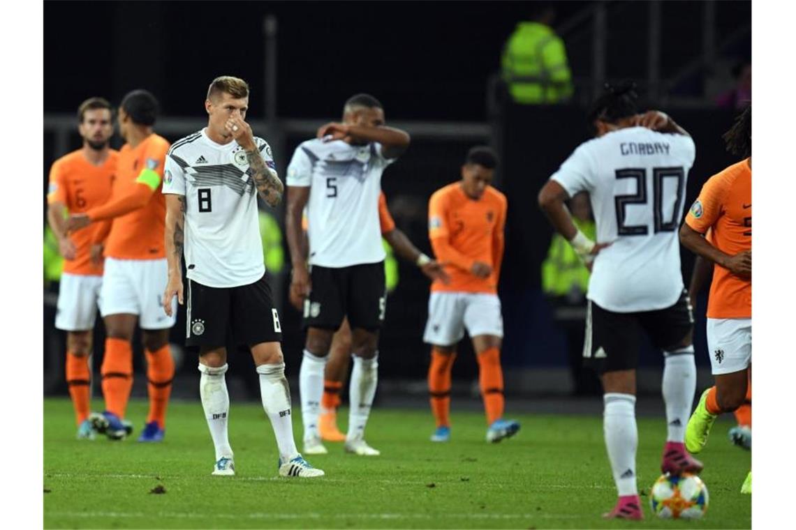Während die Niederländer feiern, stehen die DFB-Spieler enttäuscht in Hamburg auf dem Platz. Foto: Daniel Reinhardt