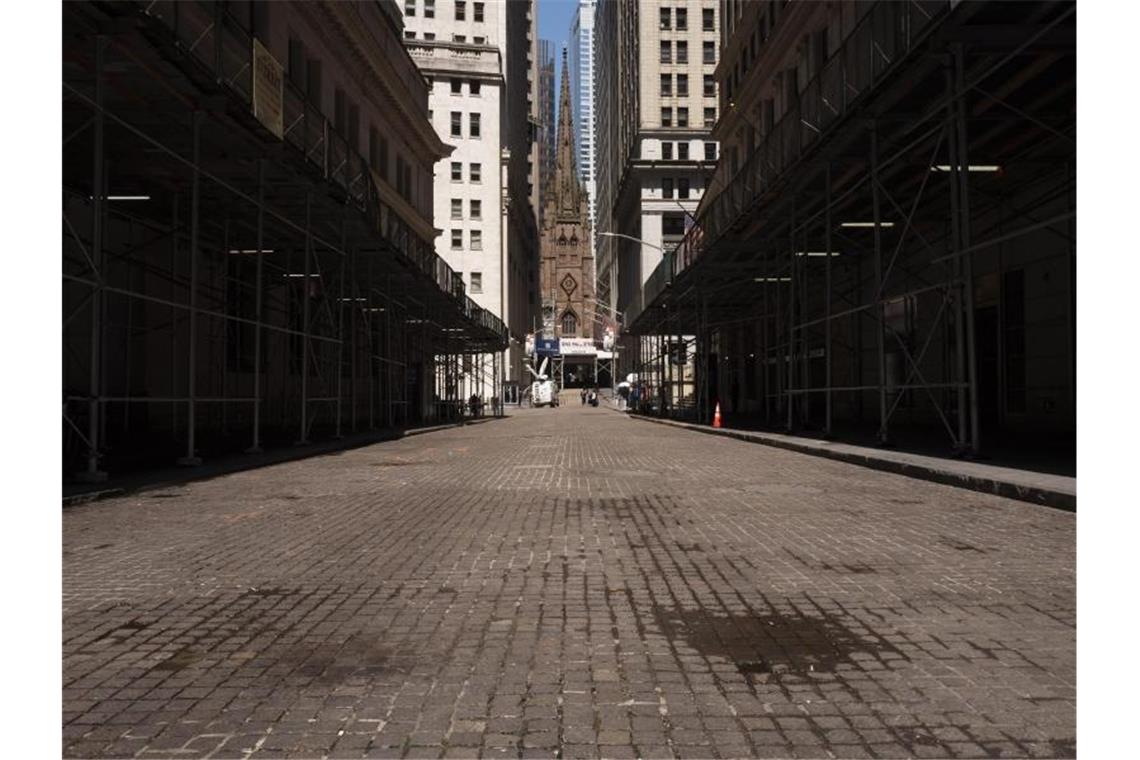 Während die Wall Street nahezu menschenleer ist, steigen die Kurse wieder an. Foto: Mark Lennihan/AP/dpa