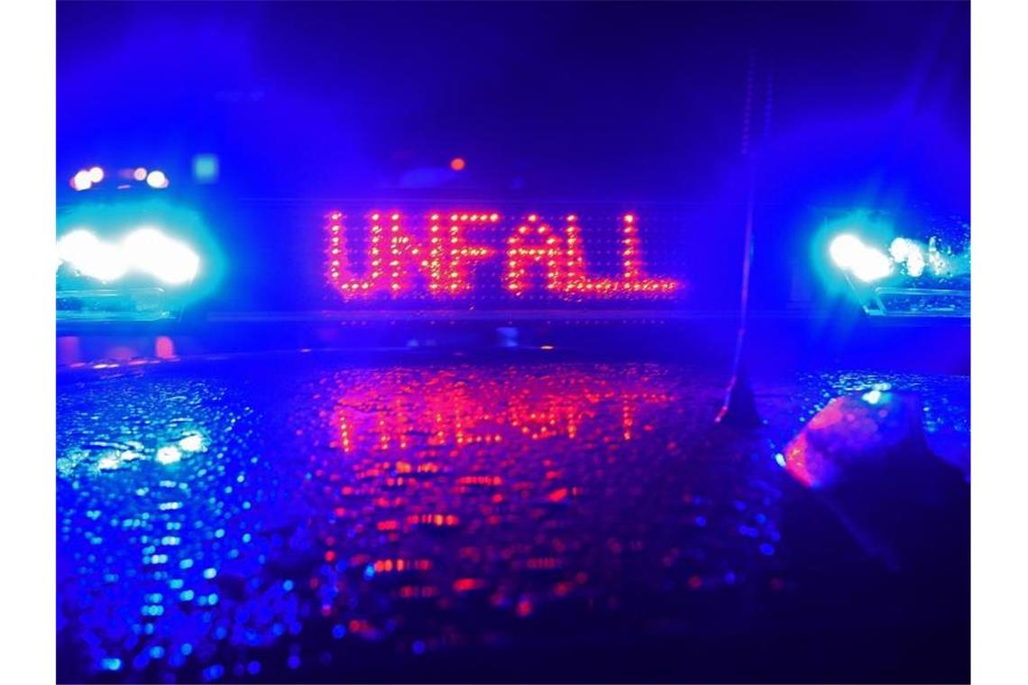 Während einer Unfallaufnahme spiegelt das Blaulicht und der Schriftzug "Unfall" auf dem Dach eines Polizestreifenwagens. Foto: Stefan Puchner/Archiv