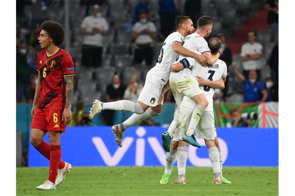 Während Italiens Spieler in München den Halbfinal-Einzug feiern, schaut Belgiens Axel Witsel (l) enttäuscht drein. Foto: Federico Gambarini/dpa