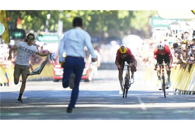 Während Jonas Abrahamsen und Mauro Schmid (r) in Toulouse um den Sieg sprinten, läuft ein Flitzer (l) auf die Zielgerade.
