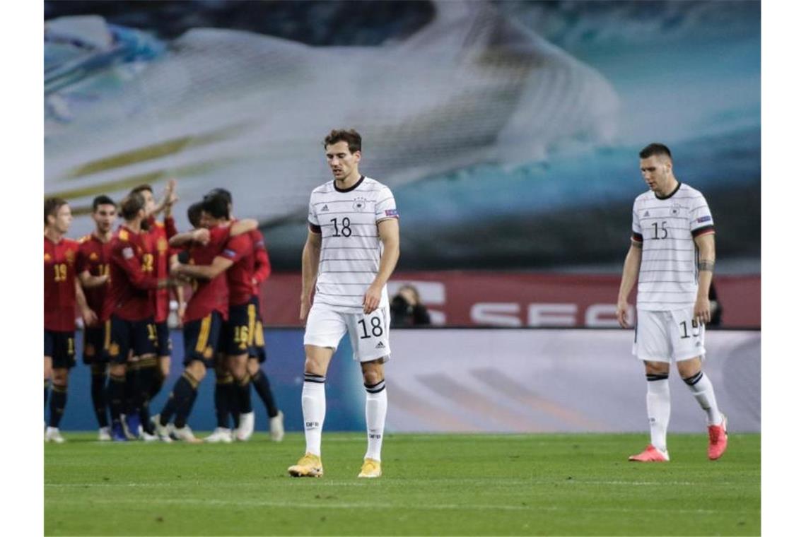 Während Spaniens Spieler einen Treffer feiern lassen Leon Goretzka (M) und Niklas Süle (r) enttäuscht den Kopf hängen. Foto: Daniel Gonzales Acuna/dpa