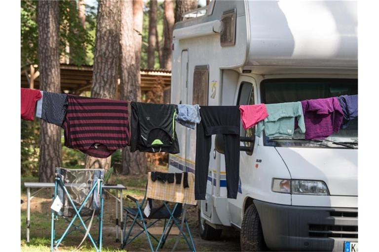 Wäsche hängt auf einer Leine vor einem Wohnmobil auf einem Campingplatz. Foto: Patrick Pleul/Archivbild