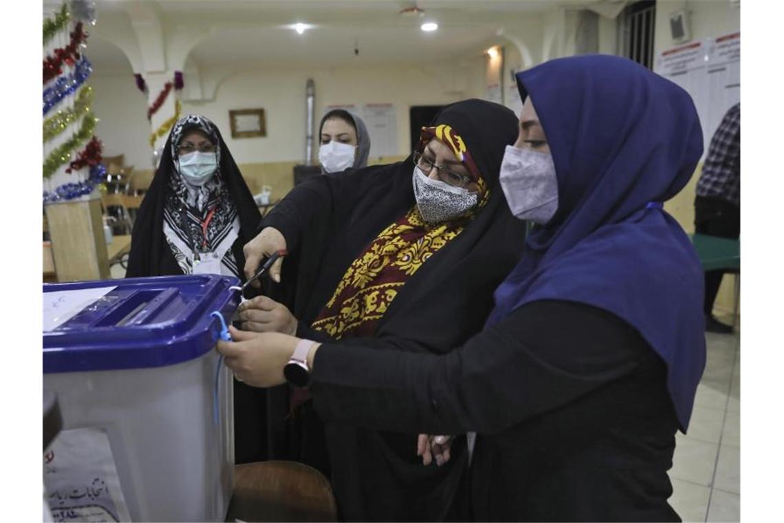 Ebrahim Raeissi gewinnt Präsidentenwahl im Iran: Was kommt? Wahlhelferinnen öffnen eine Urne in einem Wahllokal in Teheran. Foto: Vahid Salemi/AP/dpa