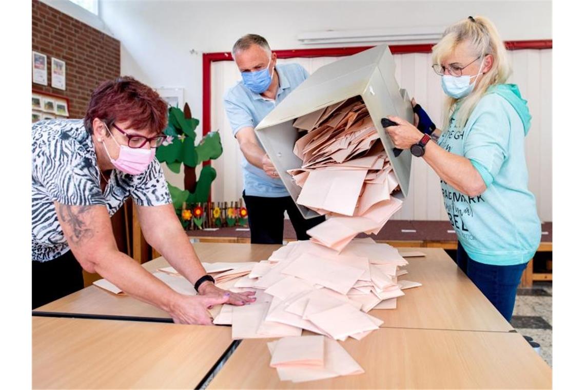 Wahlhelferinnen und ein Wahlhelfer entleeren im niedersächsischen Delmenhorst eine Wahlurne mit Stimmzetteln. Foto: Hauke-Christian Dittrich/dpa