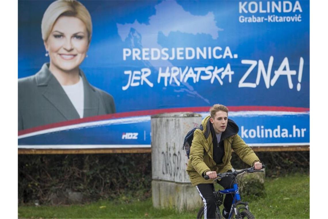 Milanovic gewinnt erste Runde in Kroatien Wahlplakat von Amtsinhaberin Kolinda Grabar-Kitarovicder in Zagreb. Foto: Darko Bandic/AP/dpa