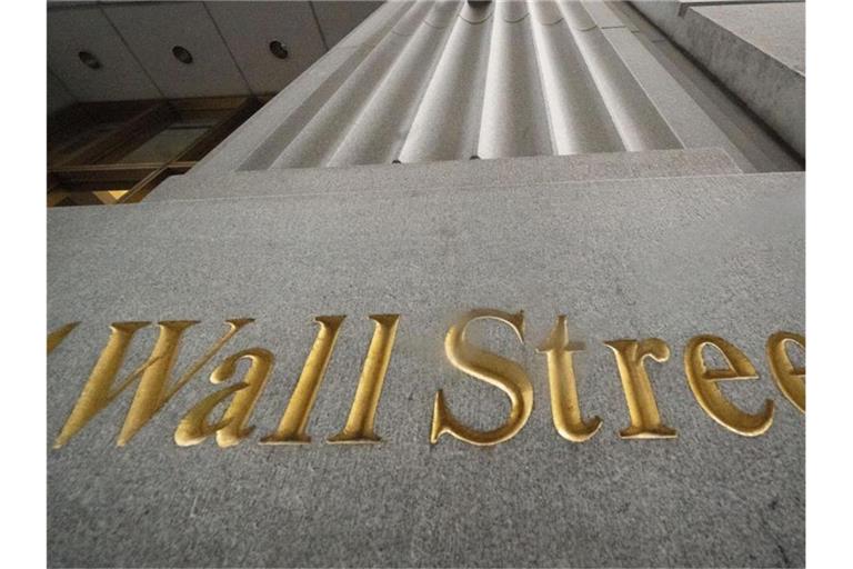 „Wall Street“ steht geritzt an der Fassade eines Gebäudes. Foto: Mark Lennihan/AP/dpa