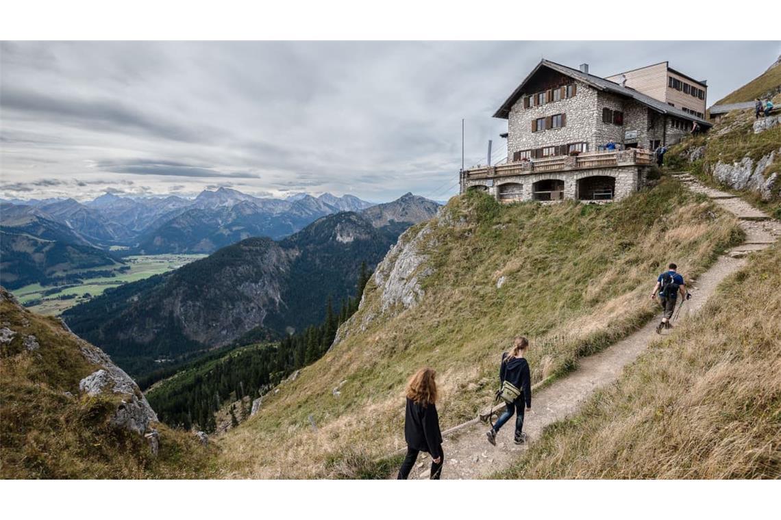 Wanderer gehen zur Bad Kissinger Hütte: Nicht nur Schutzort, sondern auch Informationsquelle: Hüttenwirte wissen meist sehr genau, wie es um die umliegenden Routen bestellt ist.