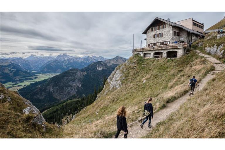 Wanderer gehen zur Bad Kissinger Hütte: Nicht nur Schutzort, sondern auch Informationsquelle: Hüttenwirte wissen meist sehr genau, wie es um die umliegenden Routen bestellt ist.
