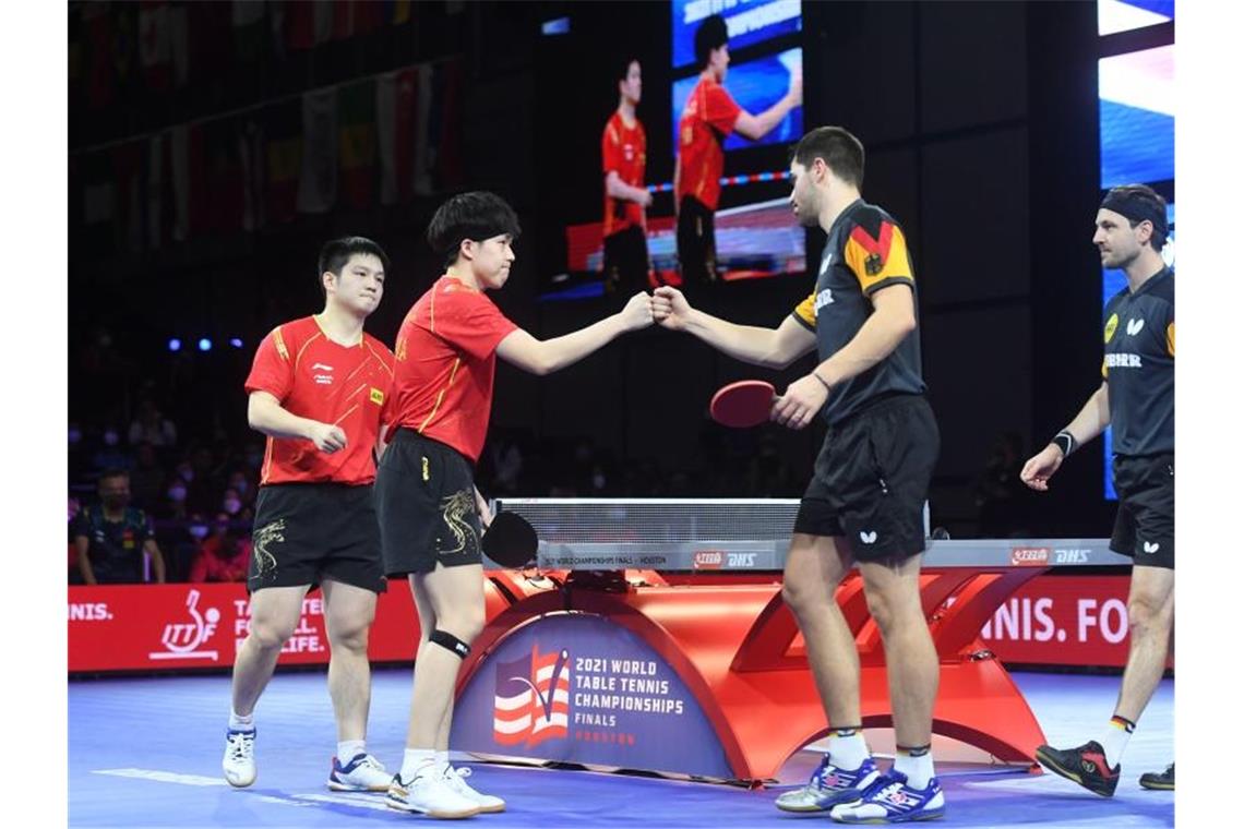 Wang Chuqin (2.v.l.) und Fan Zhendong (l) nach dem Spiel gegen Patrick Franziska (2.v.r.) und Timo Boll am vergangenen Donnerstag. Foto: Wu Xiaoling/XinHua/dpa