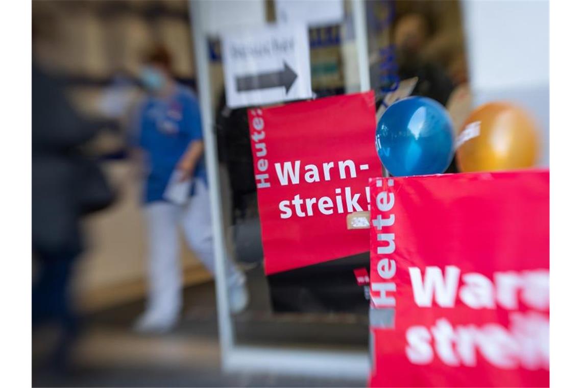 „Warnstreik!“ steht auf einem Schild vor dem Eingang des städtischen Klinikums Gütersloh. Foto: Friso Gentsch/dpa