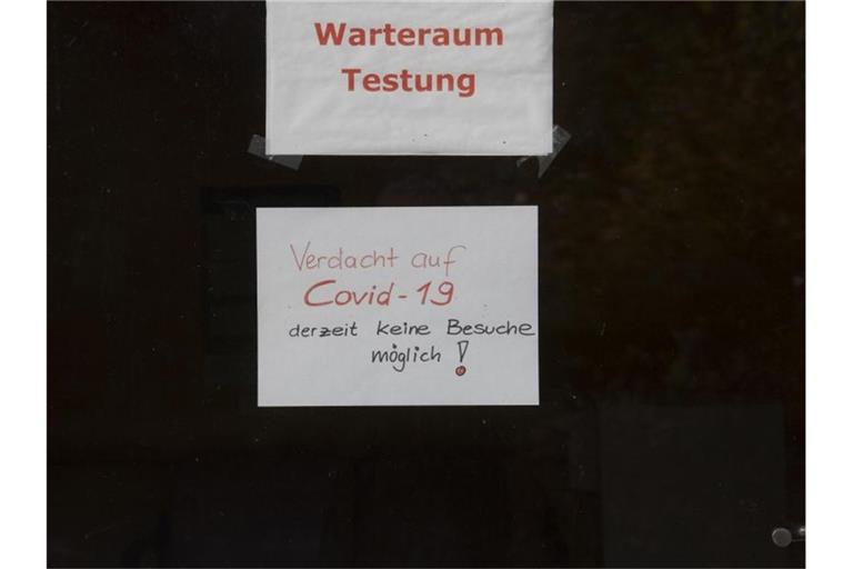 "Warteraum Testung" und "Verdacht auf Covid-19 derzeit keine Besuche möglich!" steht auf Zetteln an einer Scheibe in dem Seniorenheim, in dem es zum Corona-Ausbruch gekommen ist. Foto: Paul Zinken/dpa