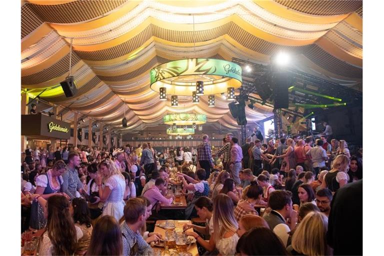 Wasen-Besucher feiern im Festzelt. Foto: Sebastian Gollnow/dpa