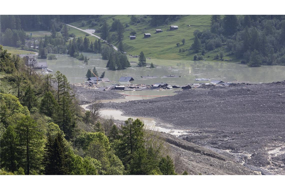 Bilder des Tages Wasser aus dem Fluss Lonza fließt über Schlamm und Stein, nachdem sich ein See auf den letzten Häusern des Dorfes Blatten gebildet hat.