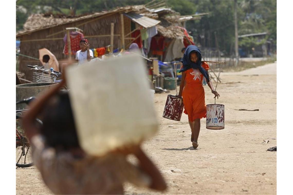 Wasser schleppen in Myanmar: Das Klimaphänomen El Niño führte in dem wasserreichen Land vor drei Jahren dazu, dass Stauseen austrockneten. Foto: Nyein Chan Naing/EPA/dpa/Archiv