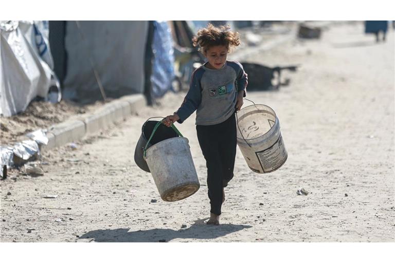 Wasser wird zum Luxus: Kind rennt mit leeren Eimern zu einer Wasserstelle in Gaza