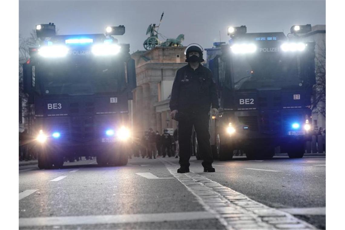 Wasserwerfer der Polizei stehen bei der Corona-Demo am Brandenburger Tor bereit. Foto: Michael Kappeler/dpa