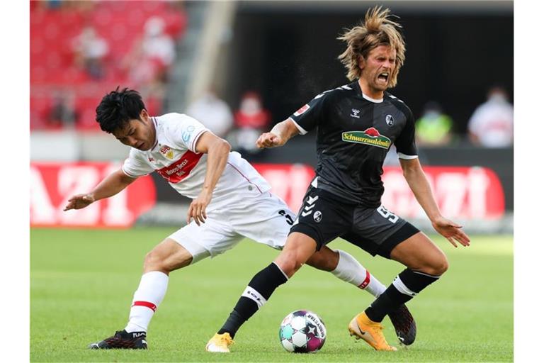 Wataru Endo (l) kämpft um den Ball. Foto: Tom Weller/dpa/Archivbild