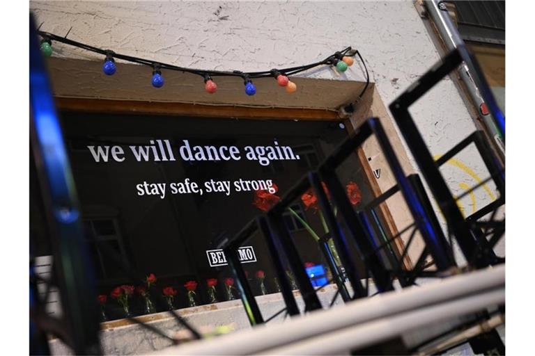 „we will dance again. stay safe, stay strong“ (dt. Wir werden wieder tanzen. Bleibt sicher, bleibt stark.) steht auf dem Fenster einer geschlossenen Bar. Foto: Sebastian Gollnow/dpa