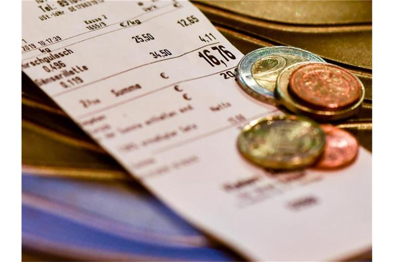 Wechselgeld liegt auf dem Kassenbon in einer Metzgerei. Foto: Jens Kalaene/zb/dpa