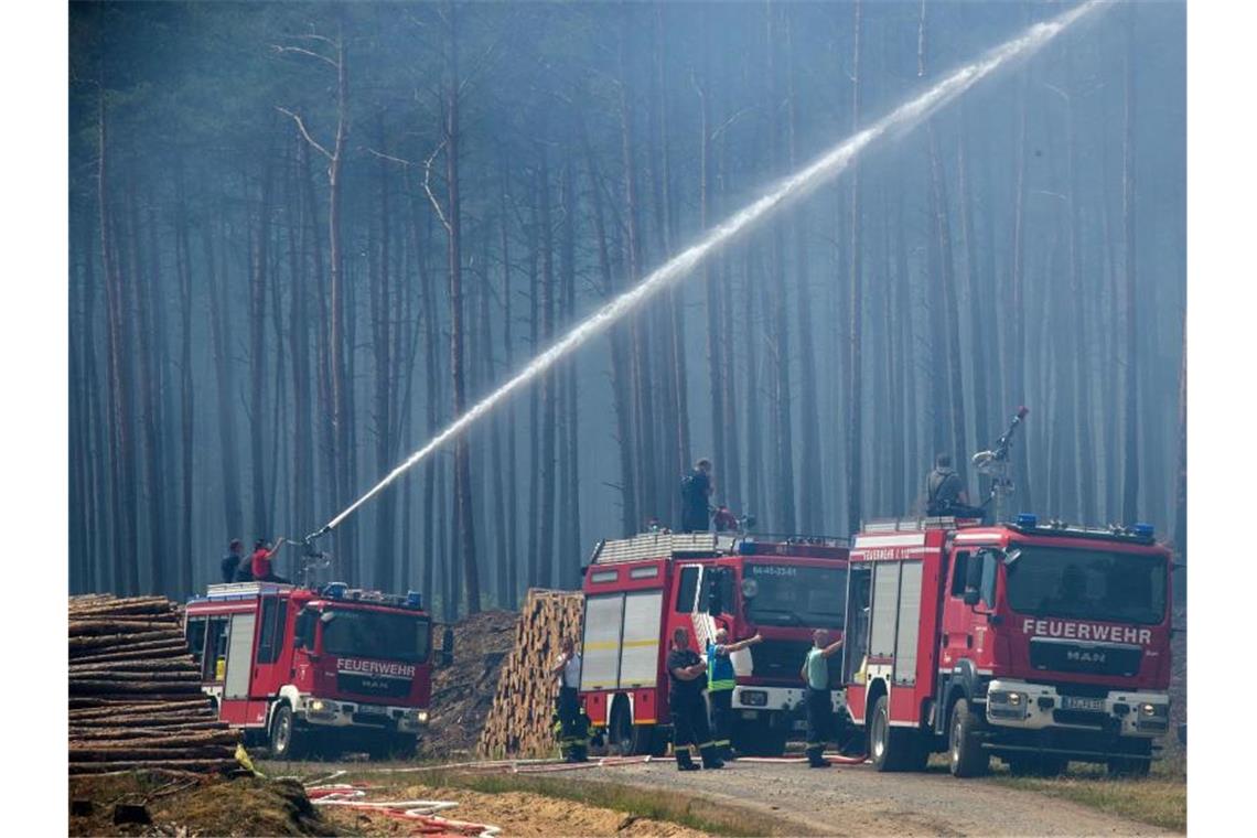 Wasserwerfer und Räumpanzer bei Brandbekämpfung Wegen des Brands auf dem ehemaligen Truppenübungsplatz bei Lübtheen in Mecklenburg-Vorpommern mussten Hunderte Menschen ihre Wohnungen verlassen. Foto: Jens Büttner