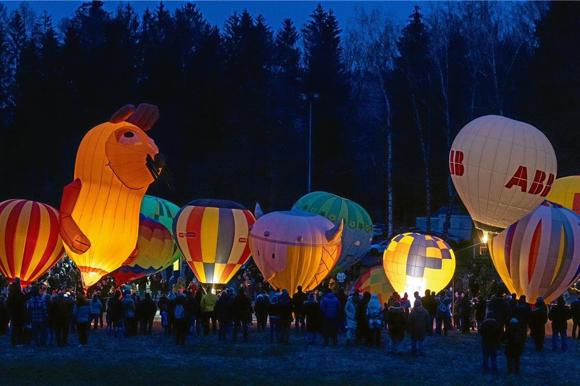 Modellballonglühen in Sechselberg: Leuchtende Farben und fröhliche Gestalten Wegen des starken Windes wurde das Event vergangenes Jahr spontan vom Festplatz Althütte zum Sportplatz Sechselberg verlegt. Der Waldrand hier verspricht etwas mehr Schutz vor Böen.