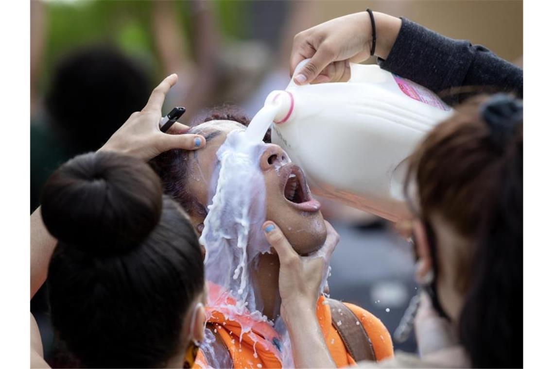 Wegen Tränengas-Einsatz wird das Auge einer Demonstrantin mit Milch ausgespült. Foto: Carlos Gonzalez/Star Tribune/AP/dpa