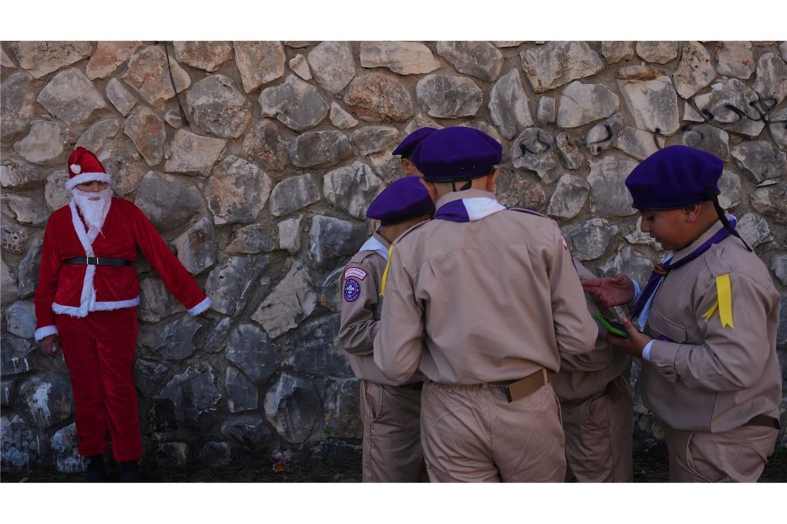 Weihnachten in Nazareth - Jugendlicher im Weihnachtsmannkostüm wartet mit Pfadfindern auf Weihnachtsparade