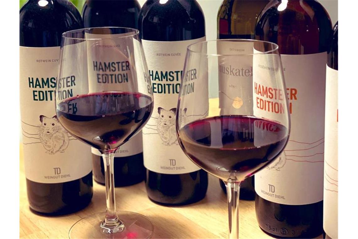 Weingläser und Flaschen der „Hamster Edition“ stehen beim Weingut Diehl. Foto: Weingut Diehl/dpa/Archivbild