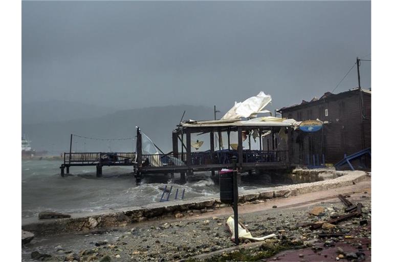 Wellen brechen im Hafen von Argostoli in einer Taverne ein. Foto: Nikiforos Stamenis/AP/dpa