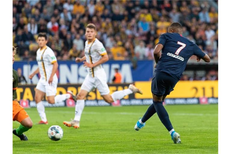 Weltmeister Kylian Mbappe (r) lässt Dynamo-Keeper Kevin Broll keine Chance und schiebt zum 3:0 für PSG ein. Foto: Robert Michael