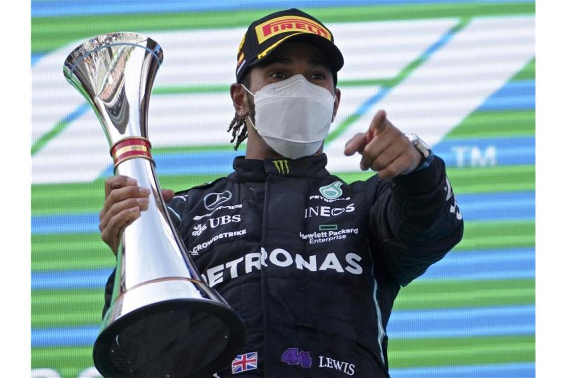 Weltmeister Lewis Hamilton bejubelt seinen Sieg beim Großen Preis von Spanien auf dem Podium. Foto: Emilio Morenatti/AP Pool/dpa