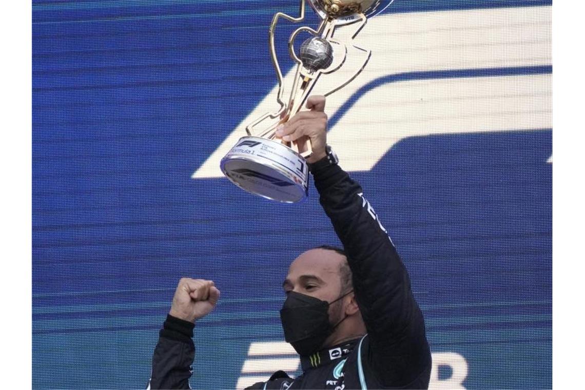 Weltmeister Lewis Hamilton mit der Siegertrophäe. Foto: Sergei Grits/AP/dpa