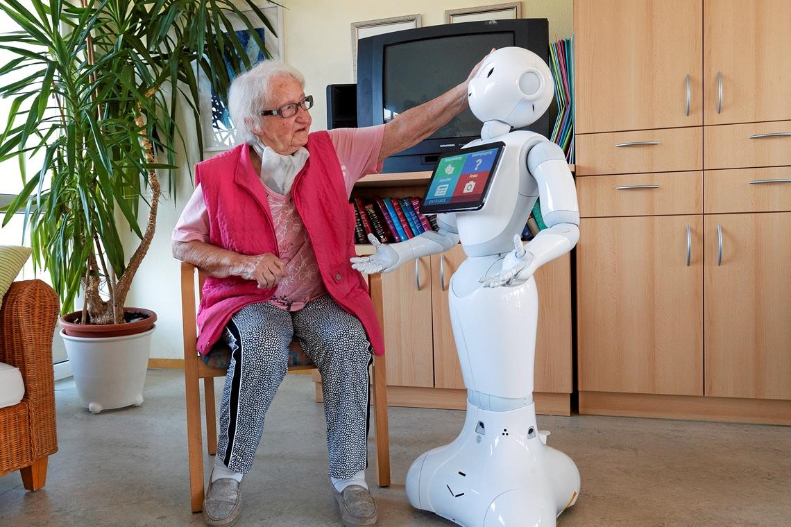 Wenn man Paul über den Kopf streicht, fängt er an zu kichern. Das ist so charmant, dass Bewohnerinnen wie Gerta Mooser gleich mitlachen müssen. „Lachen ist gesund. Gerade im Heim brauchen wir das“, sagt die Seniorin. Fotos: J. Fiedler