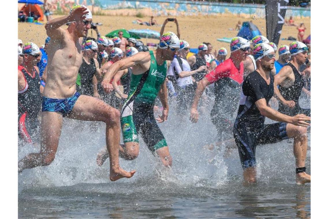 Hitze in Deutschland bringt möglicherweise Temperaturrekord Wer tut sich das bei diesen Temperaturen freiwillig an? Teilnehmer des Helenesee-Triathlons in Frankfurt (Oder) starten zum Schwimmen. Foto: Patrick Pleul