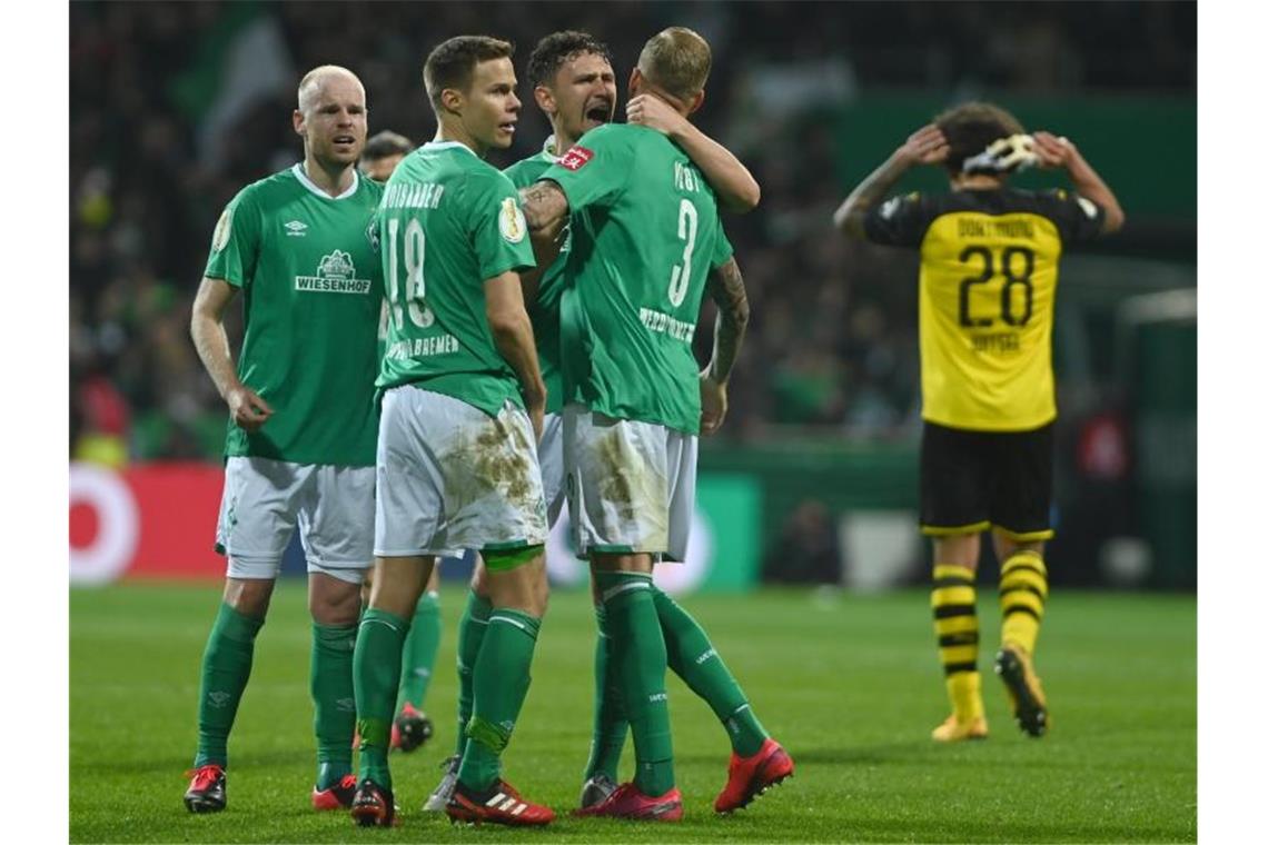 Werder Bemens Spieler (l) freuen sich nach dem Spiel über den Heimerfolg gegen den BVB. Foto: David Hecker/dpa