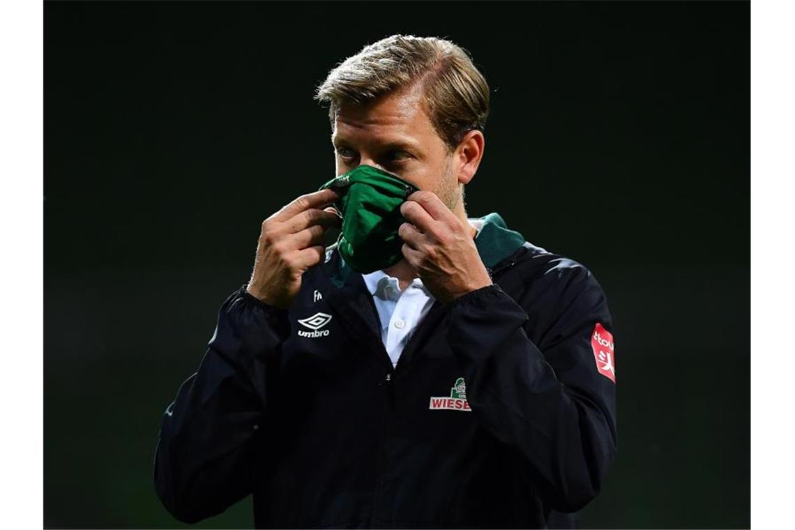 Werder-Trainer Florian Kohfeldt geht nach dem Spiel mit Maske vom Platz. Foto: Stuart Franklin/Getty Images Europe/Pool/dpa