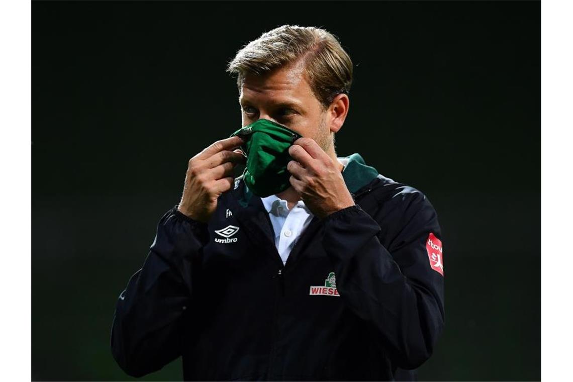 Kein Frust bei Werder: „Rückschlag, aber kein Knockout“ Werder-Trainer Florian Kohfeldt geht nach dem Spiel mit Maske vom Platz. Foto: Stuart Franklin/Getty Images Europe/Pool/dpa